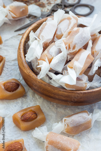 Homemade soft caramel candy with almonds, vertical