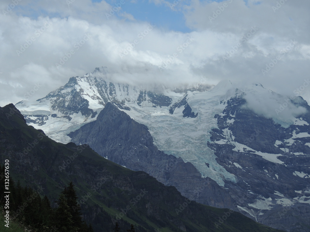 Alpine glacier with mountain peak hidden in the clouds