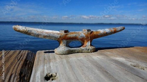 Fotografie rusty metal cleat on wooden dock