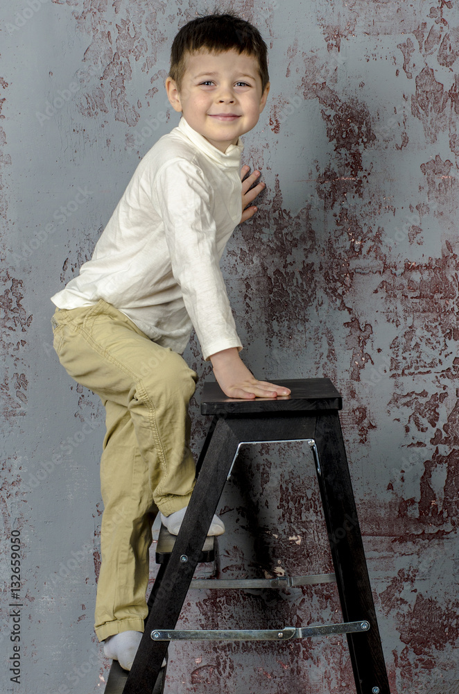 Little baby boy in plaid shorts climbs the ladder ladder
Little baby boy in plaid shorts climbs the ladder ladder