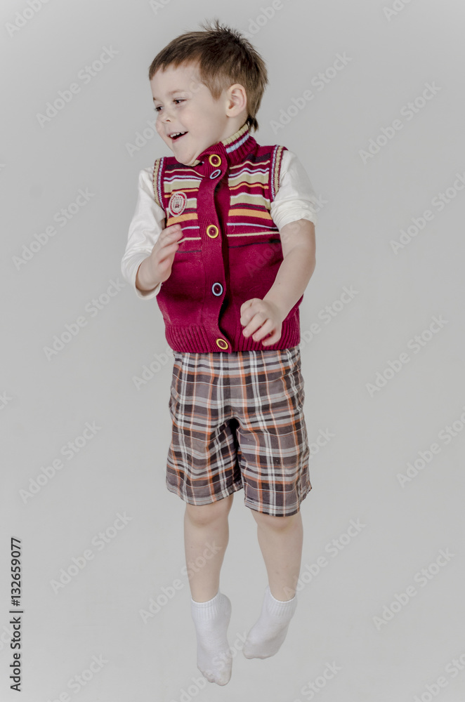 Little baby boy in plaid shorts and vest jumps
Little baby boy in plaid shorts and vest jumps