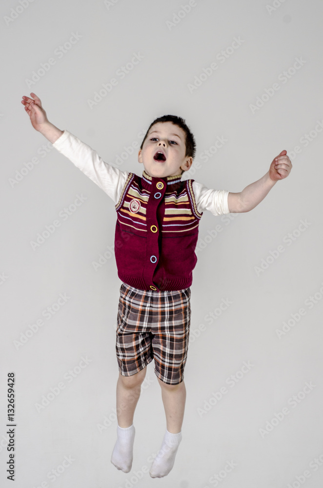 Little baby boy in plaid shorts and vest jumps
Little baby boy in plaid shorts and vest jumps