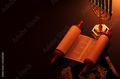 Photo Religion and Judaism concept with candle lit scene of the holy Torah and a menor