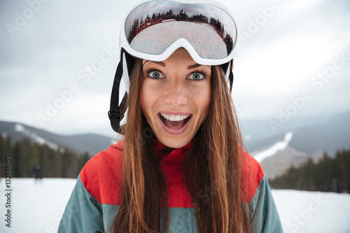 Young excited happy lady snowboarder on the slopes