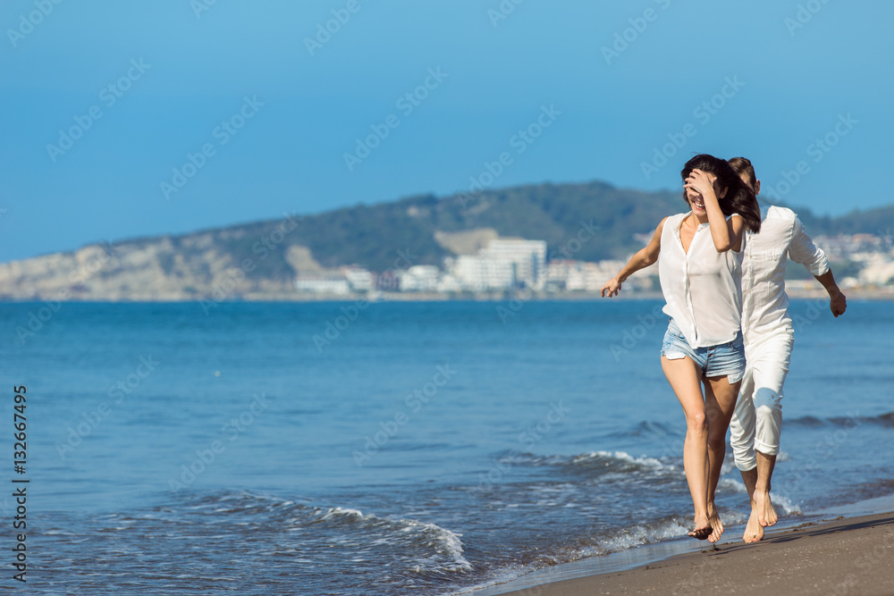 happy couple running on the beach