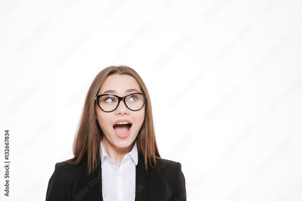 Smart business woman in eyeglasses looking up at copy space