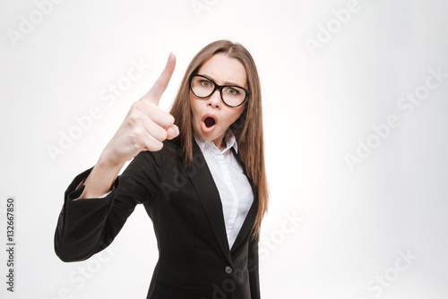 Young serious businesswoman pointing finger at camera