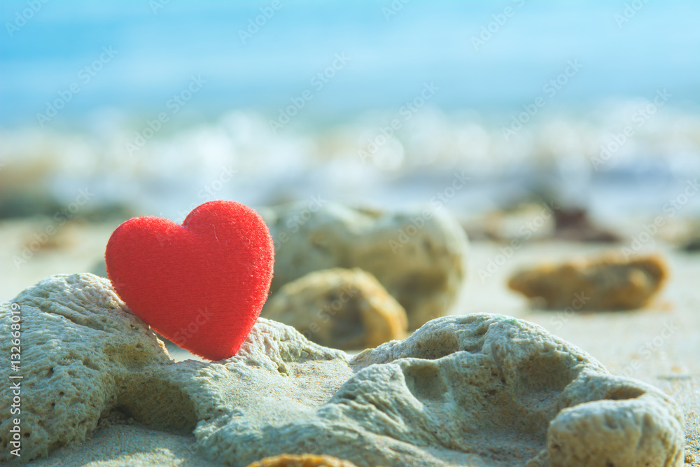 Fototapeta premium red heart on coral beach with blue sea background