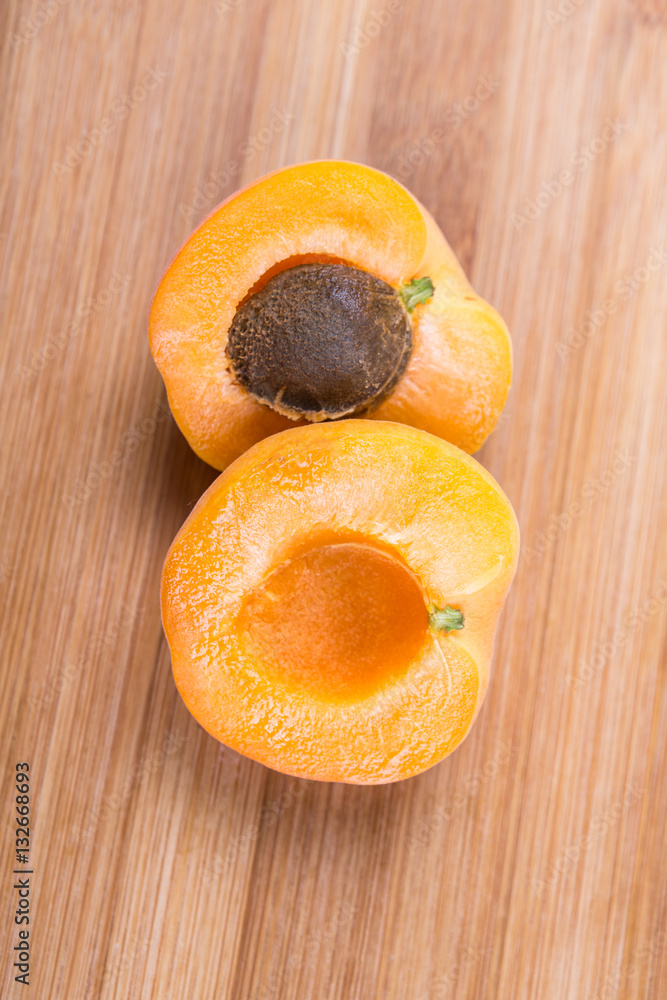 Whole and cut ripe apricots isolated on a wood background