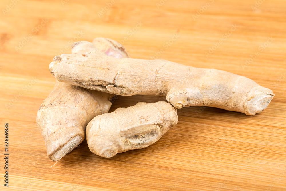 Whole ginger root isolated on a wood background Whole ginger root isolated on a wood background