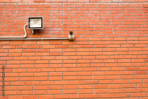 Security camera and led flood light at the brick wall