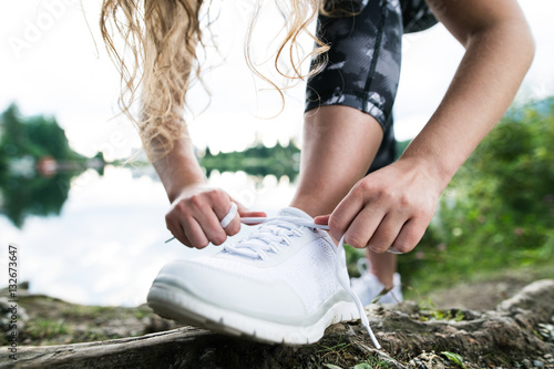 Close up of an unrecognizable young runner tying shoelaces