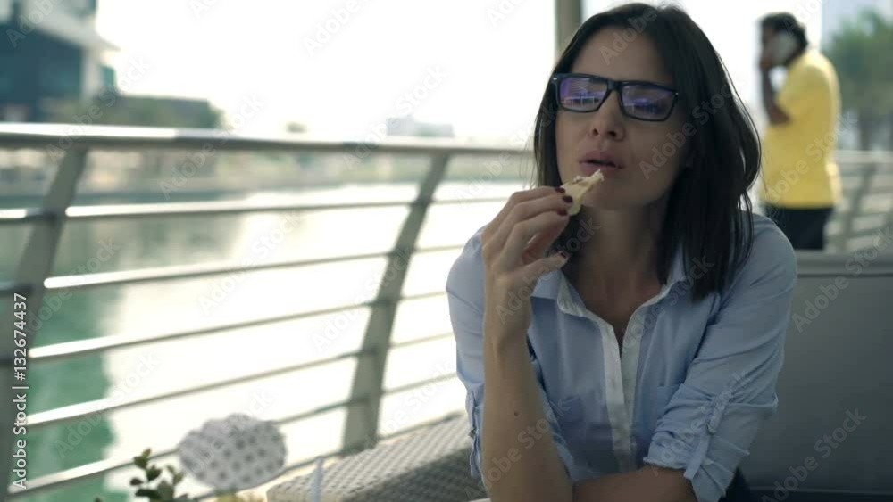 Young businesswoman eating snack sitting in cafe in city
Young businesswoman eating snack sitting in cafe in city