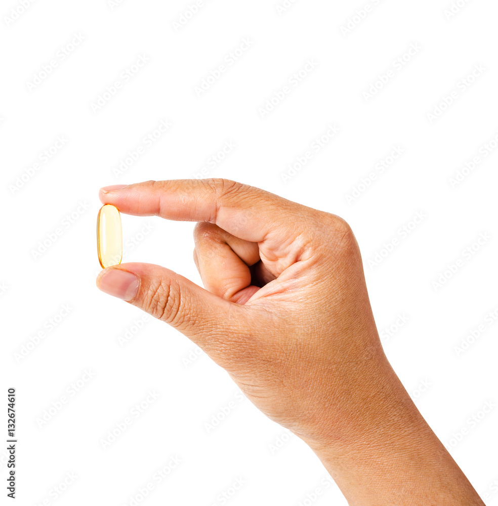 hand with fish oil capsule isolated on white hand with fish oil capsule isolated on white