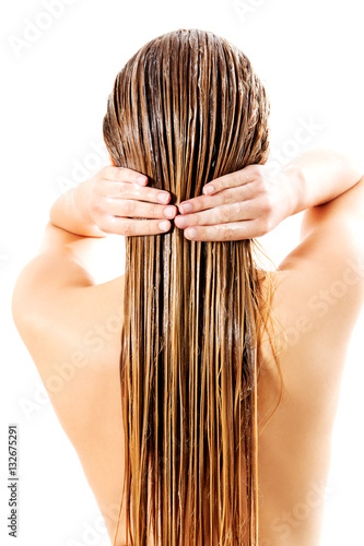 Woman applying hair conditioner. Isolated on white.