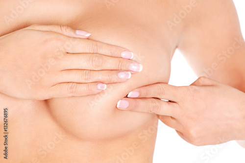 Young woman examining her breast