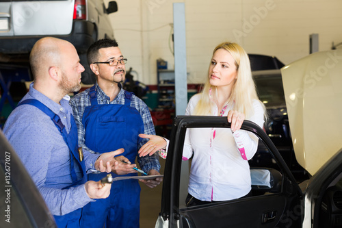 Woman and two auto mechanics