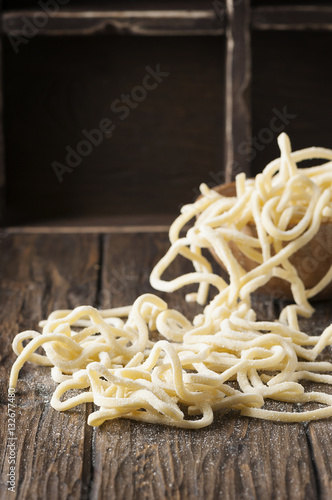 Italian homemade uncooked pasta on the wooden table