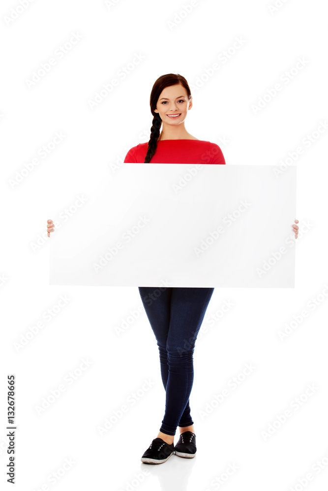 Beautiful young woman holding a blank banner