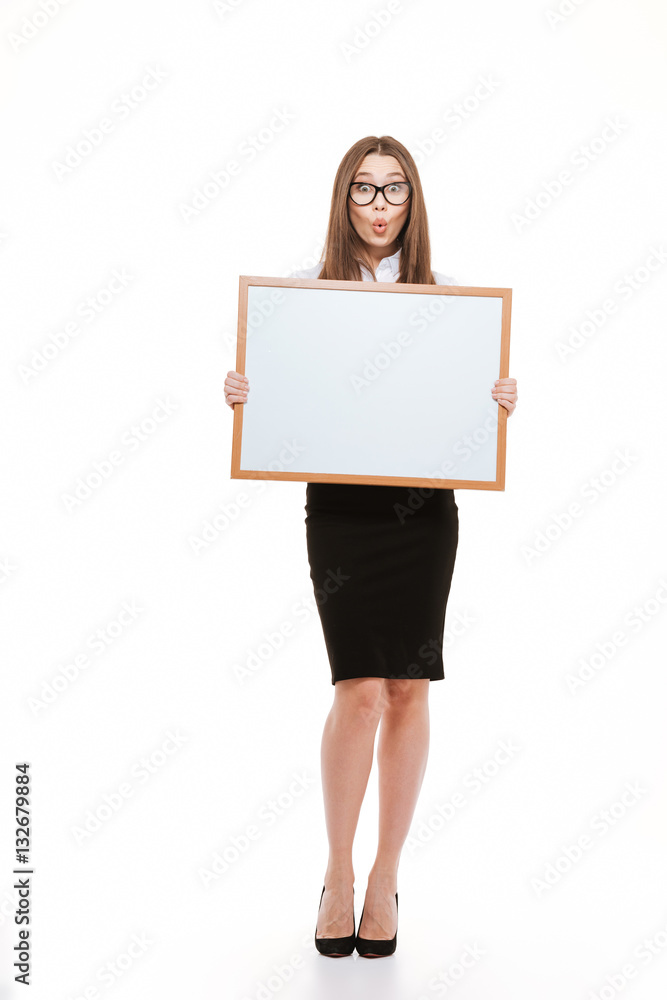 Portrait of an astonished young business woman holding blank board Portrait of an astonished young business woman holding blank board