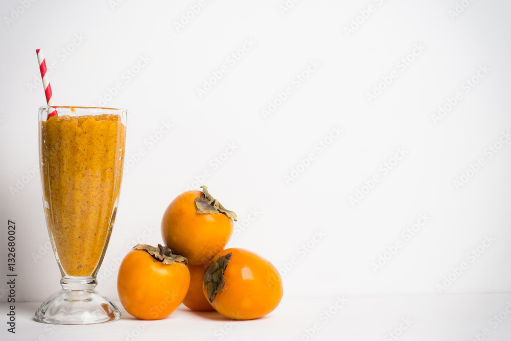 Persimmon smoothie with carrot and orange on wooden background Persimmon smoothie with carrot and orange on wooden background