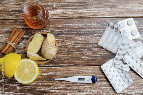 Obraz na plátně Ginger, lemon, honey and  different drugs  with thermometer on wooden background