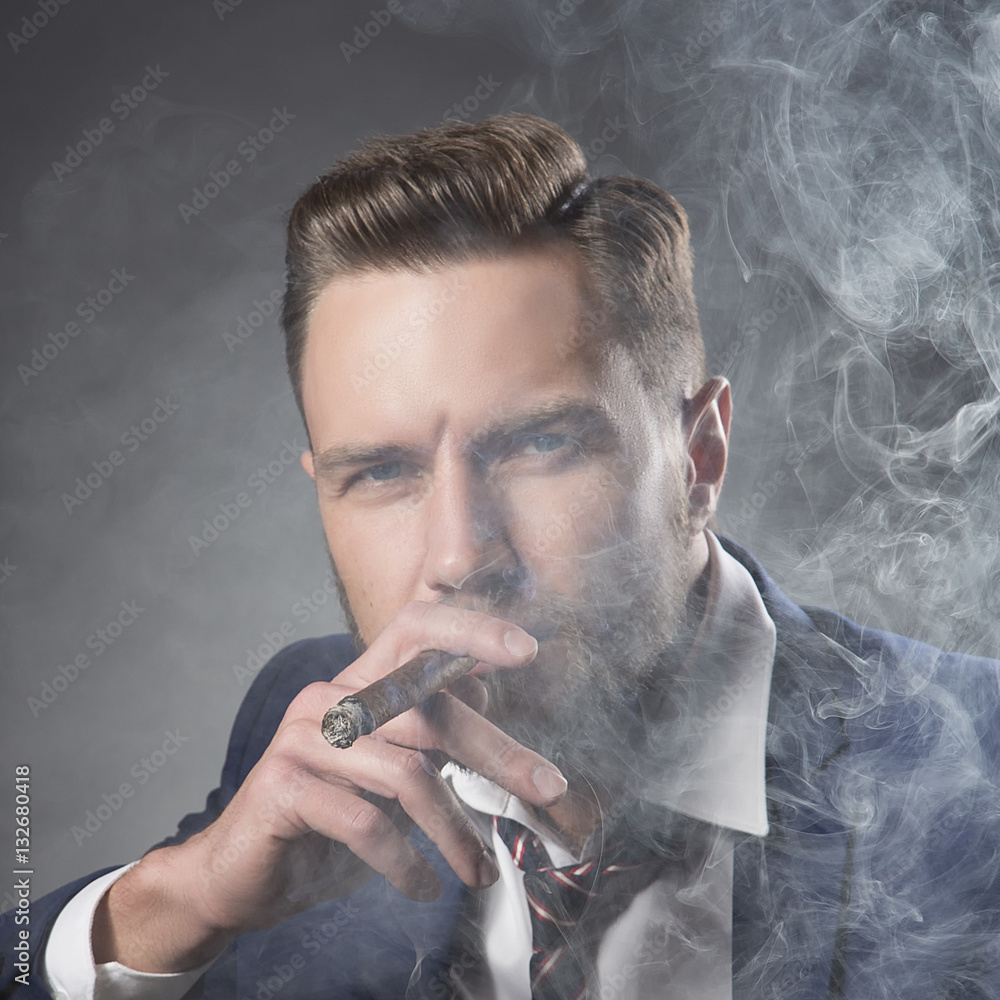 Man with hair style and beard smoking cigar Stock Photo | Adobe Stock