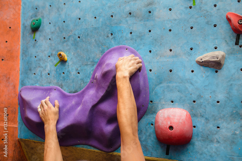 Muscular Climber hand on the bouldering climbing wall grip close-up