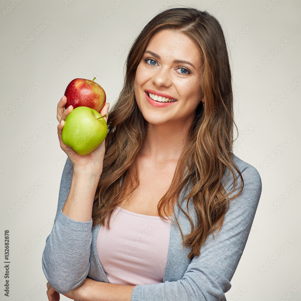 smiling young woman holding two apples, red and green. smiling young woman holding two apples, red and green.