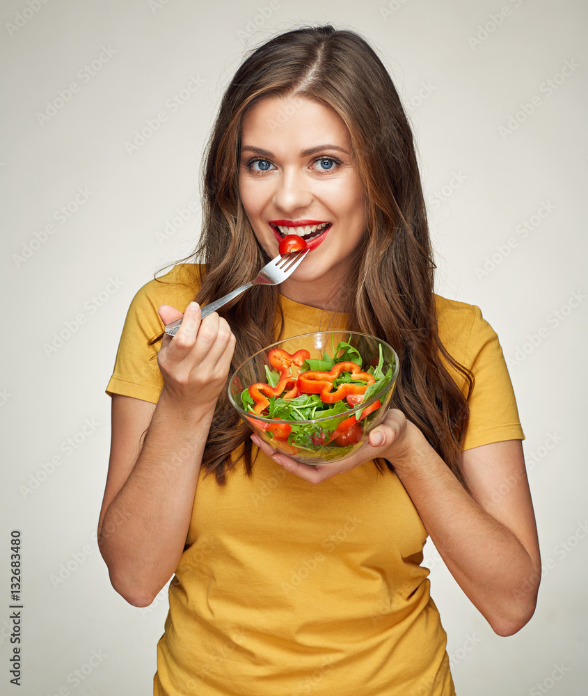 smiling woman eatin vegatable salad with fork. smiling woman eatin vegatable salad with fork.