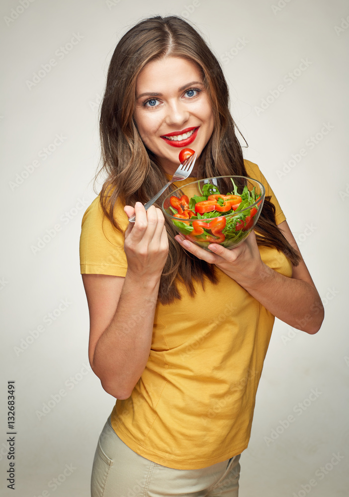 toothy smiling woman eating vegatable salad with glass bowl. toothy smiling woman eating vegatable salad with glass bowl.