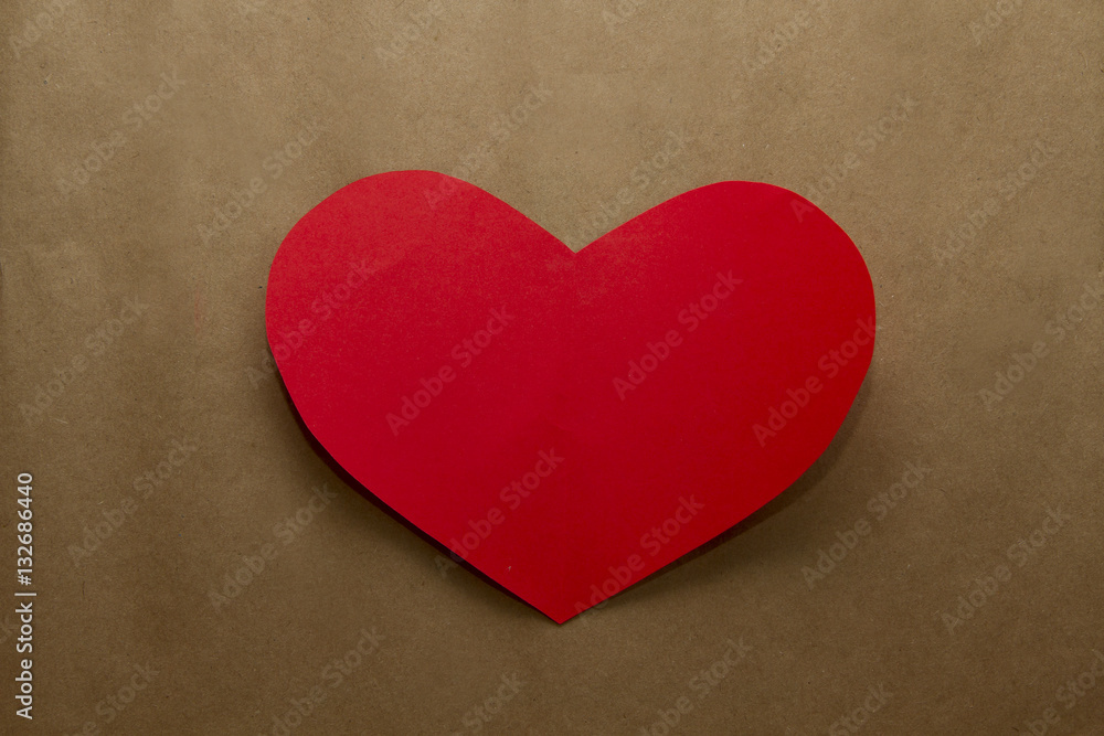 Red paper heart on the brown craft paper background