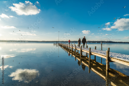 Menschen und M  wen am Holzsteg am Starnberger See im Winter