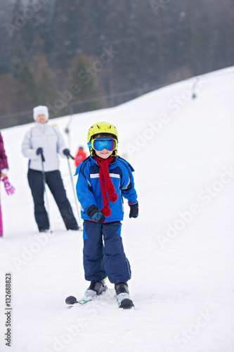 Young child, skiing on snow slope in ski resort in Austria