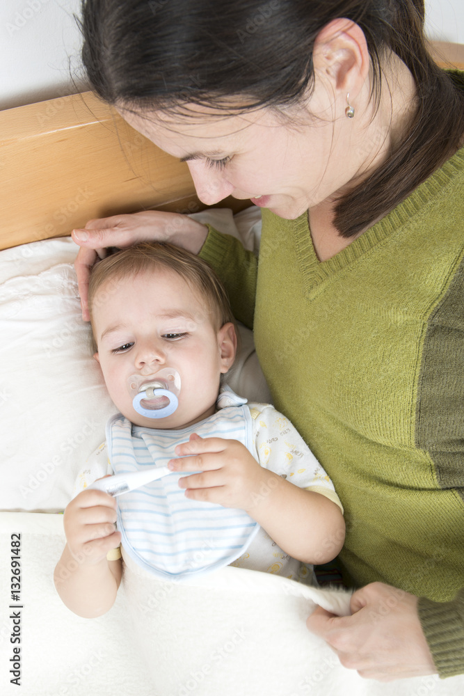 Baby with fever looking at thermomether Baby with fever looking at thermomether