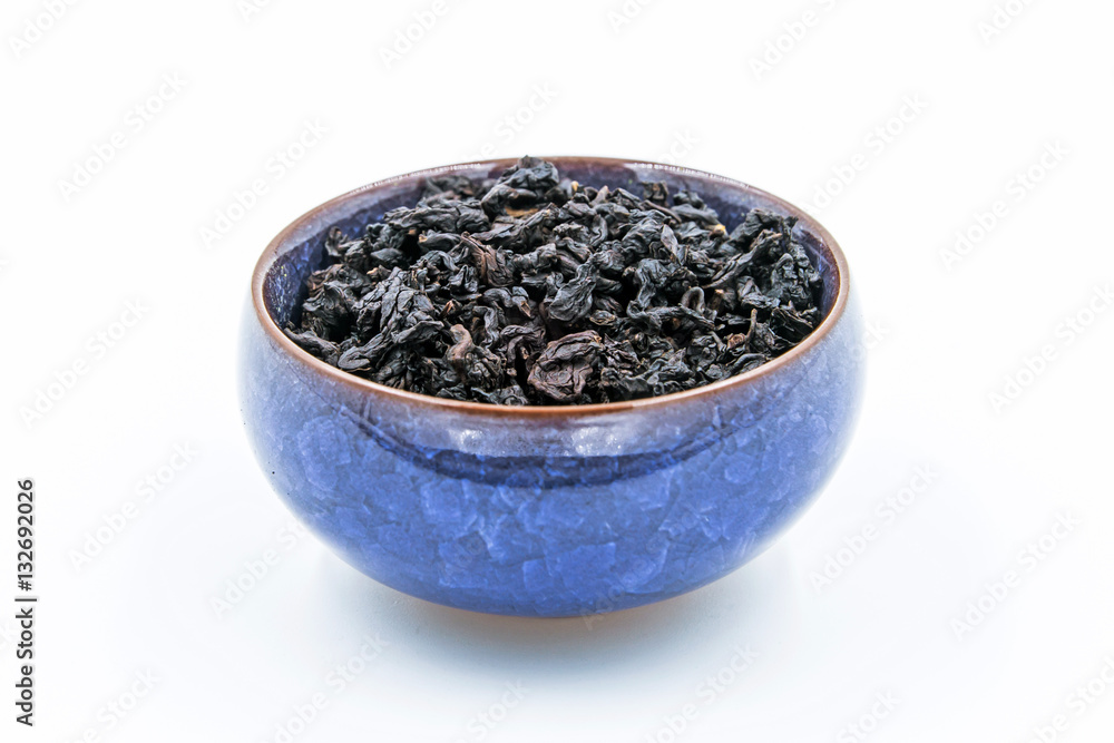 Chinese Oolong Dark Red tea (Black Tie Guan Yin) in a blue ceramic bowl Chinese Oolong Dark Red tea (Black Tie Guan Yin) in a blue ceramic bowl