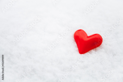 Ceramic red heart on the fresh snow