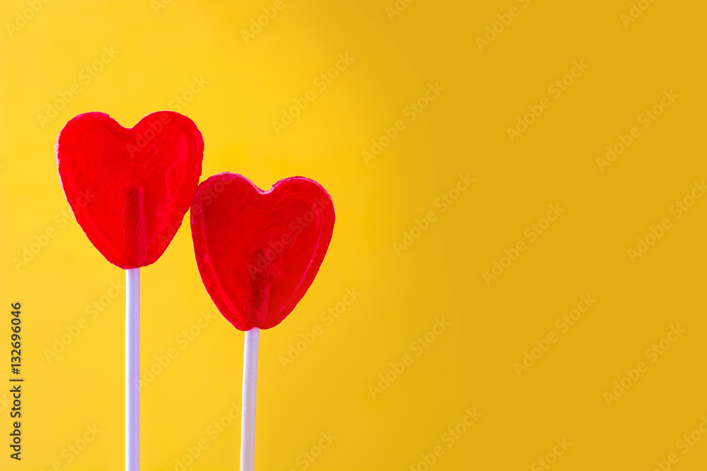 Red lollipop with heart shape on yellow background. Love concept. Valentine's Day.
Red lollipop with heart shape on yellow background. Love concept. Valentine's Day.