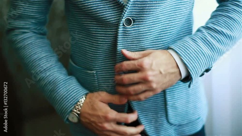 Man hands buttoning casual outfit jacket close up. Stylish well-dressed man trying on blue striped suit preparing to go out. Macho luxury fit size garment golden youth style establishment concept