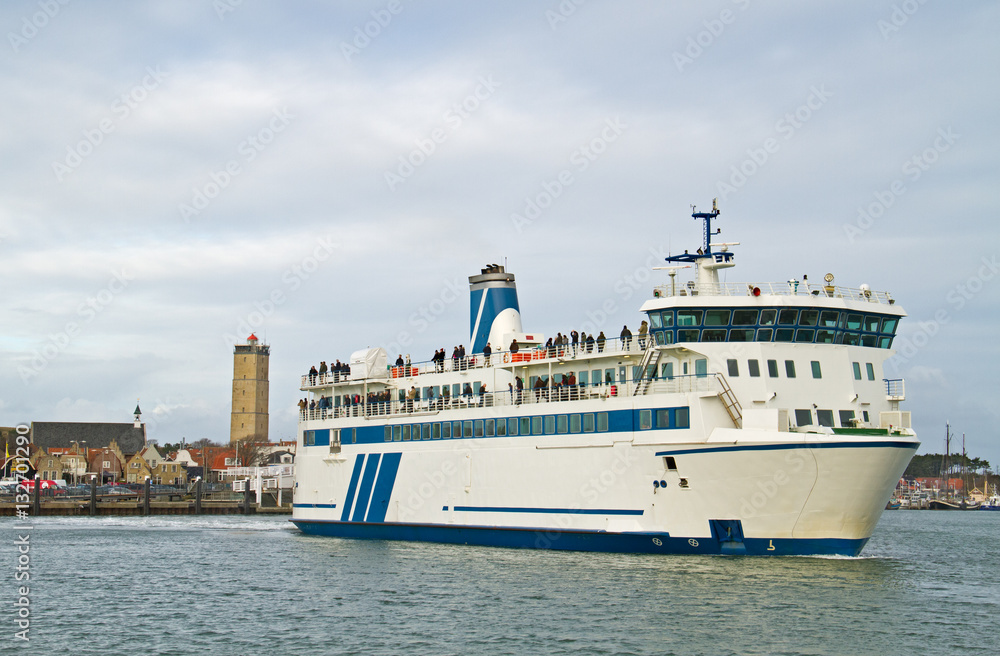 Ferry leaving harbor, in the background the lighthouse ‘Brandaris’ on the dutch island Terschelling Ferry leaving harbor, in the background the lighthouse ‘Brandaris’ on the dutch island Terschelling
