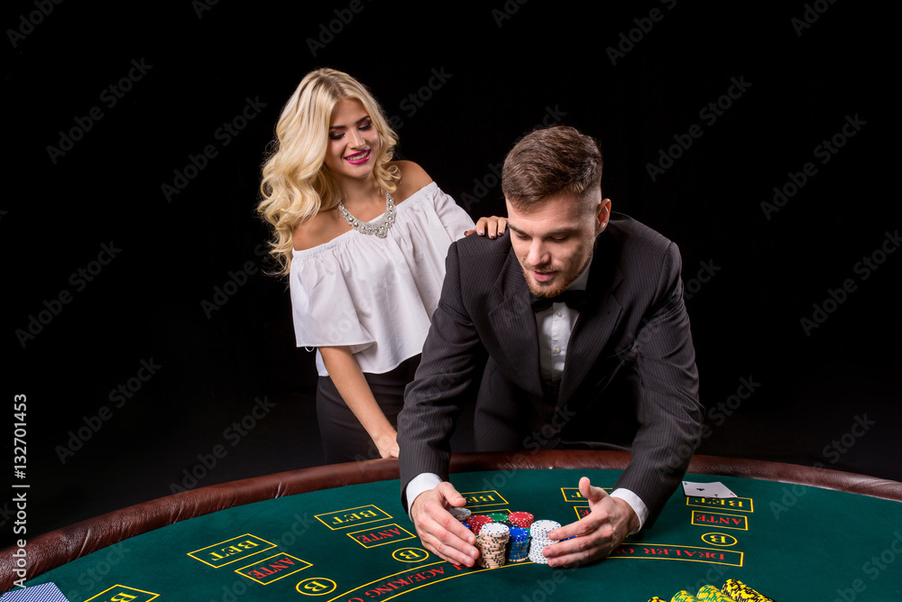 View of young, confident, man with the lady while he's playing poker game. View of young, confident, man with the lady while he's playing poker game.