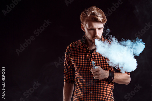 young man smoking electronic cigarette photo