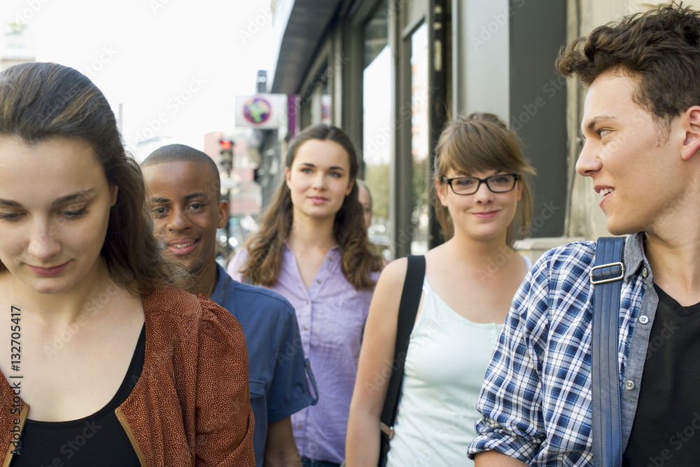 Young adult friends walking together on sidewalk Young adult friends walking together on sidewalk