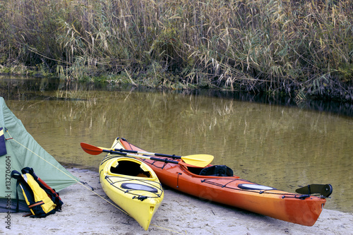 Camping with kayaks on the river bank.