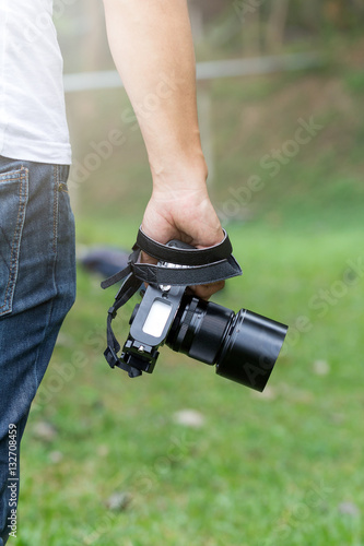 Camera in hand, photographer at the hips, rear view