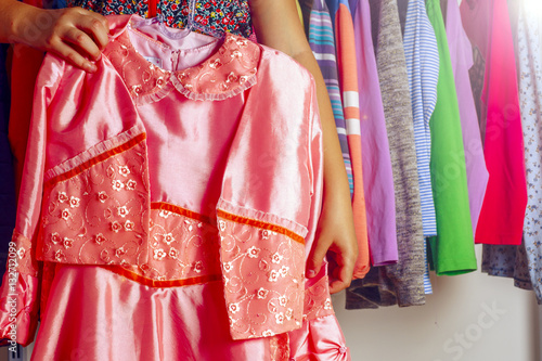 Little girl child choosing clothes to wear in wardrobe. © Lyudmyla V