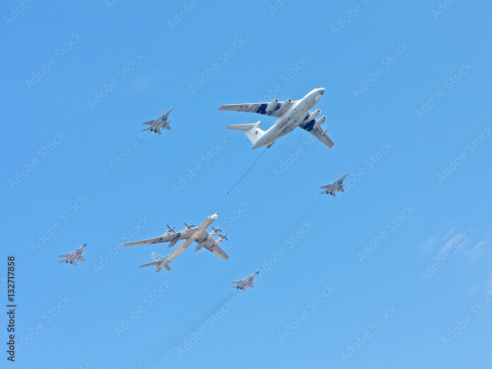 Il-78 aerial refueling tanker with Tu-95 strategic bomber and Mig-29 jet fighter fly against blue sky background
Il-78 aerial refueling tanker with Tu-95 strategic bomber and Mig-29 jet fighter fly against blue sky background