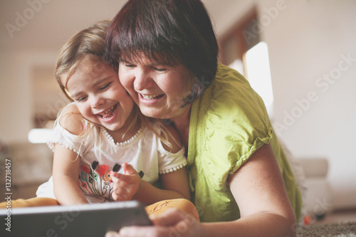 Grandmother and granddaughter using tablet.