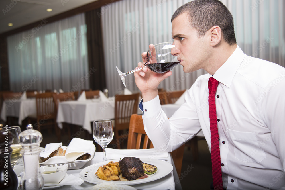 Man tasting a glass of red wine. Businessman enjoying a business lunch. Man tasting a glass of red wine. Businessman enjoying a business lunch.