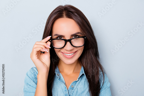 Portrait of smart smiling teacher touching her glasses
